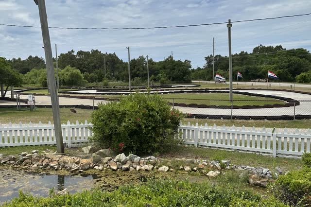 Go-kart tracks behind the white picket fence at Frisco Mini Golf and Go Karts on Hatteras Island